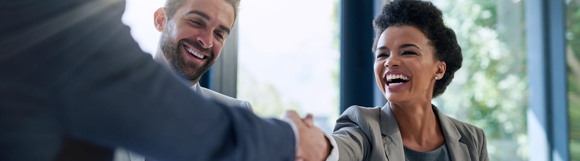 3 people meeting, 2 of them are shaking hands